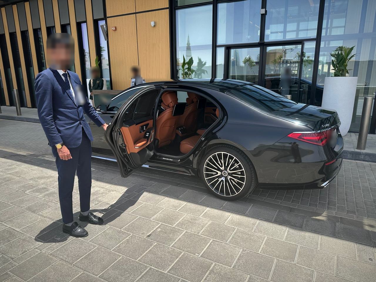 سائق من الخط الجديد يفتح باب مرسيدس S500 للعميل